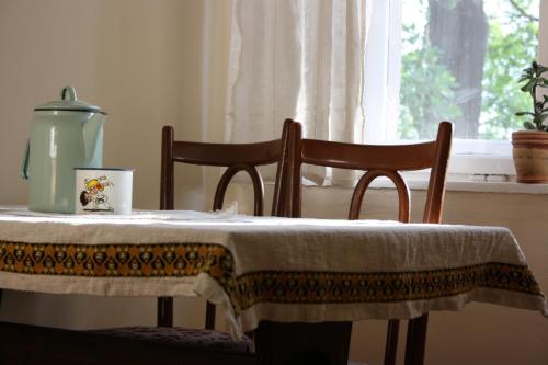 a table with two chairs and a table cloth on it at Mozaik Apartman in Kalocsa