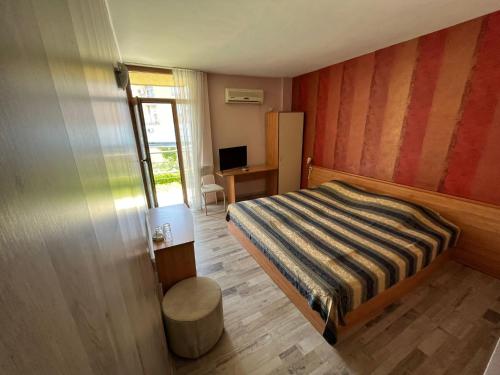 a small bedroom with a bed and a desk at HOTEL KREDO in Sliven