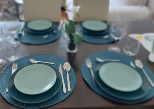 uma mesa com placas azuis e talheres em LA CASA GRADSKI VRT modern family apartment with lockable bike storage em Osijek