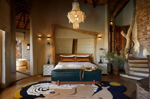 a bedroom with a bed and a chandelier at Molori Safari in Derdepoort