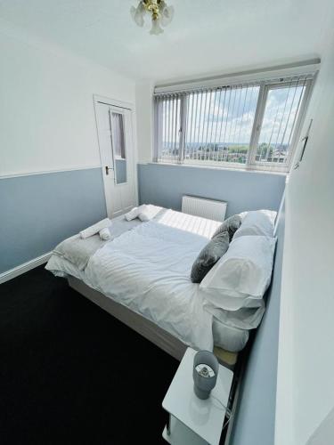 a bedroom with a large bed with a window at Stylish City Central Outskirts Sleeps 8 in Leeds