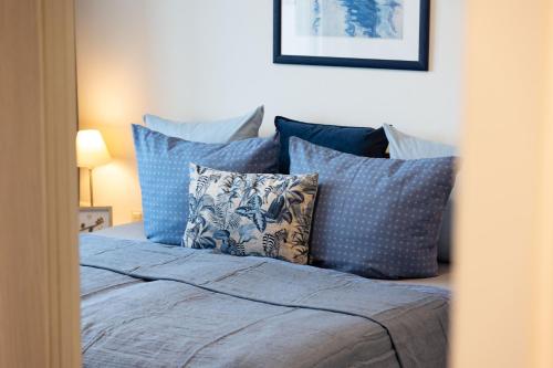 a bedroom with a bed with blue pillows at Ferienwohnung WetterFest 11 in Wittdün