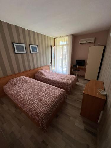 a hotel room with two beds and a table at HOTEL KREDO in Sliven