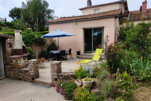 a patio with a table and an umbrella at Gîte Léperon 2 in Clisson