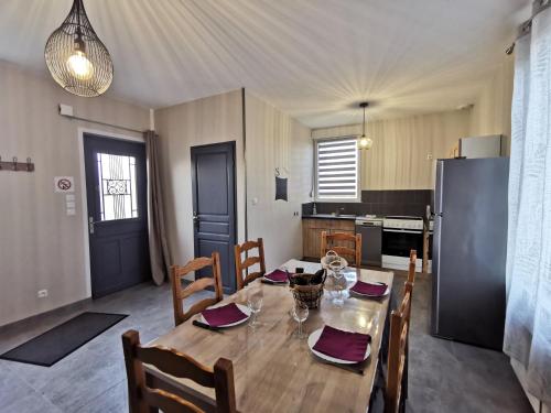 ein Esszimmer mit einem Tisch und einer Küche in der Unterkunft Gite la Ressource O' Naturel in Bonningues-lès-Ardres