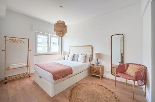 um quarto com uma cama, uma cadeira e um espelho em Sunset Bay View, Renovated Apt, By TimeCooler em Setúbal