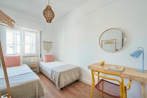 a bedroom with two beds and a desk and a mirror at Sunset Bay View, Renovated Apt, By TimeCooler in Setúbal