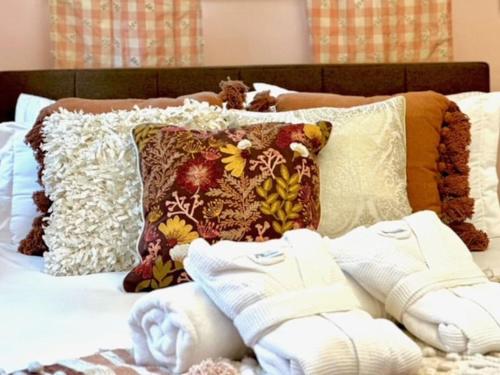 a bed with a bunch of pillows on it at Luxury Farm Stay-Glenrose Cottage-Wolf Pine Hollow in Hancock