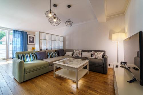 a living room with a couch and a table at Apartament Delux Mountain Aparts in Świeradów-Zdrój