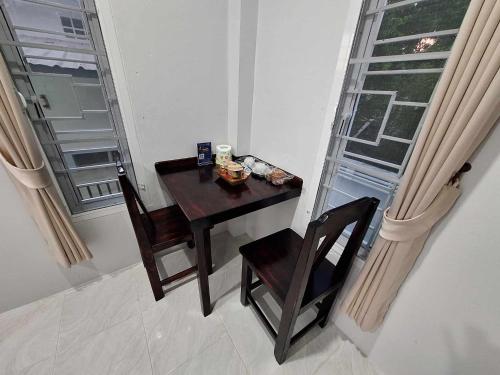 a small table and chairs in a room with a window at PPN Garden Resort in Suwannaphum