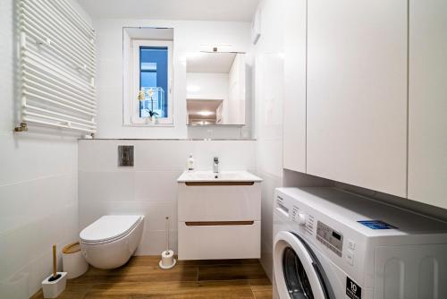 uma casa de banho com uma máquina de lavar roupa e um lavatório em Apartament Ali-Leo em Gdynia