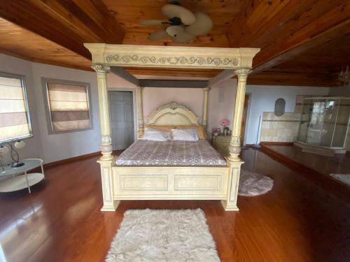 Cette chambre comprend un grand lit et un plafond en bois. dans l'établissement Chateau la Mel, à Mandeville