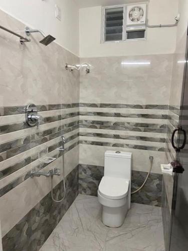 a bathroom with a toilet and a shower at Variyar Service Apartments Unit C 1st Floor in Vellore