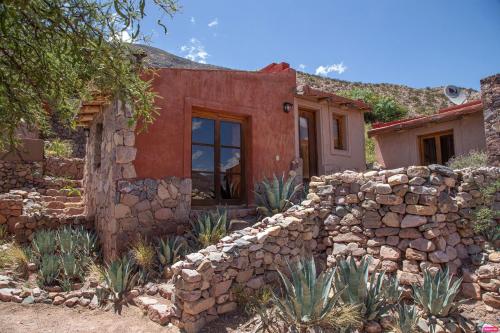 an old stone house with a stone wall at CasaCalma Hotel Boutique in Tilcara