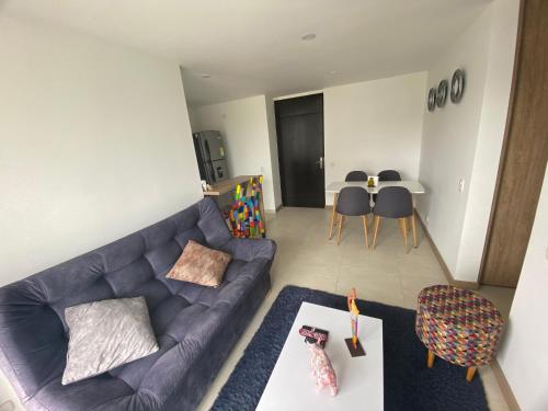 sala de estar con sofá azul y mesa en Amplio y acogedor apartamento cerca al Cable Plaza en Manizales