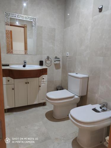La salle de bains est pourvue de toilettes, d'un lavabo et d'un miroir. dans l'établissement Luxury two bed apartment with panoramic views, à Benalmádena
