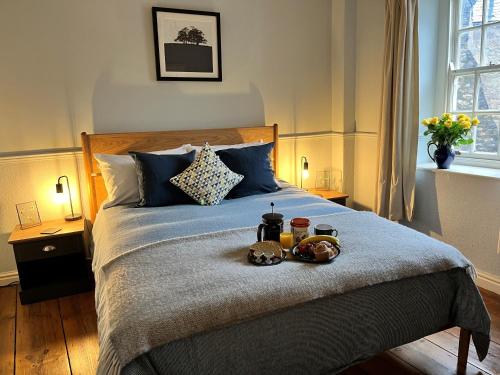 a bedroom with a bed with a tray of food on it at 5 Castle Hill in Lancaster