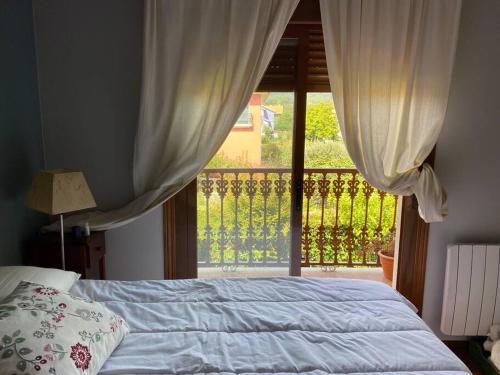 a bedroom with a bed and a large window at Casa en Cangas - Playa y casco urbano in Cangas de Morrazo