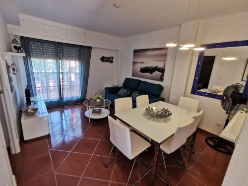 2 Piscinas en Isla Canela في هويلفا: غرفة معيشة مع طاولة وأريكة