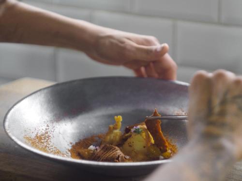 a person is stirring a pan of food at Momora distrito selva in Santa Ana
