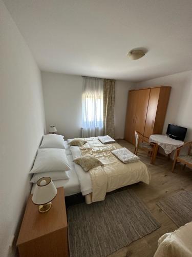 a large bedroom with two beds and a desk at Apartments Jezerce 28 in Jezerce