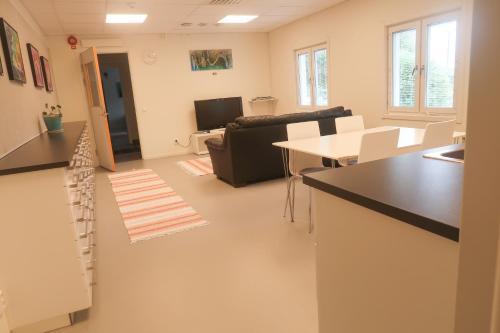 a living room with a couch and a table at Skrå hostel - bed & business in Alnön