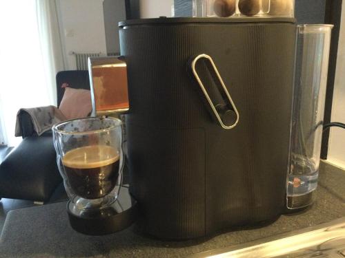 a black coffee maker sitting on a table with a glass at Villa Bootsmann mit spektakulärer Seesicht nahe Badestrand in Vitznau