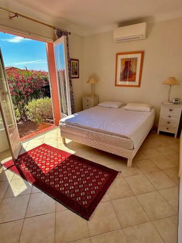 une chambre avec un lit et une porte coulissante en verre dans l'établissement Havre de paix vue mer & piscine privée, à Espéro-Pax