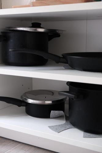 a shelf with pots and pans in a kitchen at The Secret Garden in Salerno