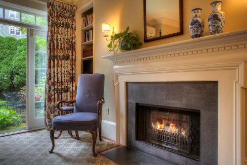 a living room with a fireplace and a blue chair at Francis Malbone House in Newport