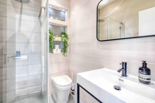 a bathroom with a toilet and a sink and a mirror at Hampstead High Flyer in London