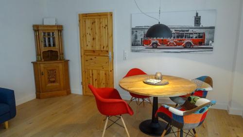 a dining room with a wooden table and red chairs at Das Schindelhaus in Groß-Umstadt