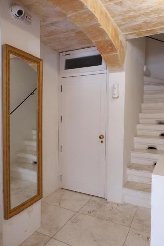 a door in a room with a mirror and stairs at SPQR Studios Valletta in Valletta