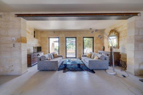 a living room with two couches and a table at Le Castel de Castillon - Maison d'exception à 10 minutes de Saint Emilion in Castillon-la-Bataille
