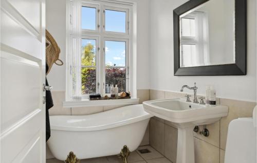 baño con bañera, lavabo y ventana en 3 Bedroom Stunning Home In Idestrup en Idestrup