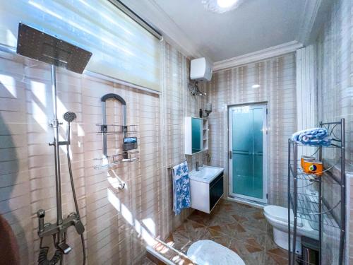 a bathroom with a shower and a toilet and a sink at Golden Touch Executive Hotel in Tema