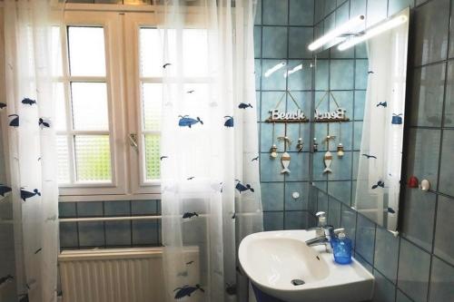 La salle de bains est pourvue d'un lavabo et d'un rideau de douche avec des chauves-souris. dans l'établissement Villa BRUYERIDE 5 personnes, à Saint-Philibert