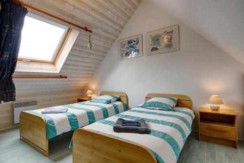 - 2 lits dans une chambre mansardée avec fenêtre dans l'établissement Villa BRUYERIDE 5 personnes, à Saint-Philibert