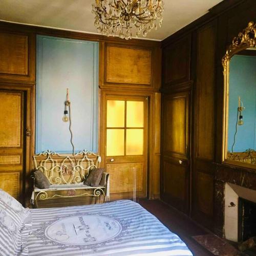 Schlafzimmer mit einem Bett und einem Kronleuchter in der Unterkunft L Annexe appartement entier in Auxi-le-Château