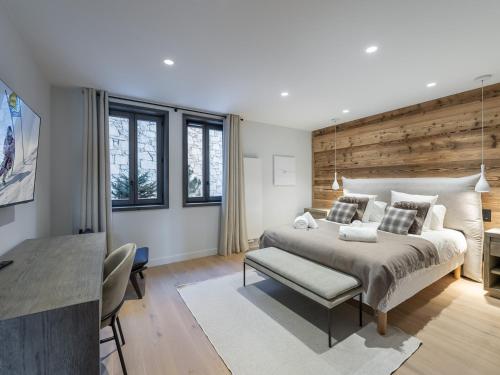 une chambre avec un grand lit avec un mur en bois dans l'établissement Appartement neuf proche pistes, 4 chambres avec sauna et cheminée - FR-1-562-63, à Courchevel