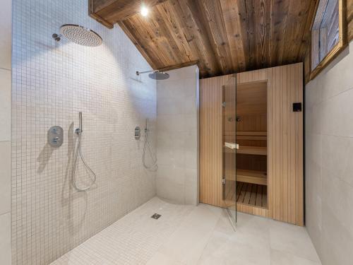 une salle de bain avec une douche avec une porte vitrée dans l'établissement Appartement neuf proche pistes, 4 chambres avec sauna et cheminée - FR-1-562-63, à Courchevel