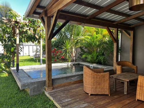 a patio with a pool and a table and chairs at Tropical 3-bedrooms Coastal Residence Creolia2 in Pointe aux Cannoniers