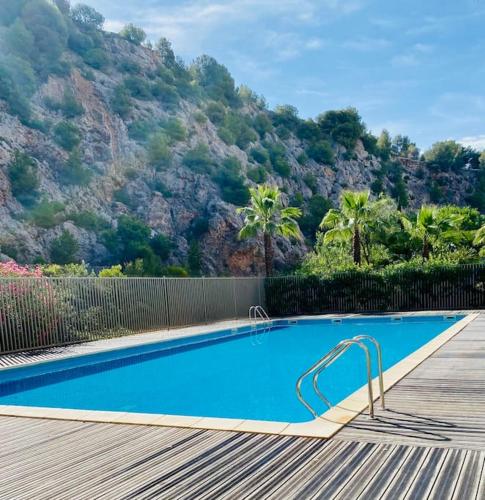 une piscine avec une montagne en arrière-plan dans l'établissement ''Le Soleil'' Superbe T3 avec vue étang et mer, clim parking et piscine, à Sète