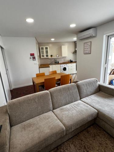 a living room with a couch and a kitchen at Casa da Praça 1 in São João da Madeira