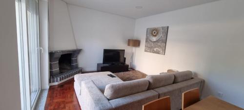 a living room with a couch and a fireplace at Casa da Praça 1 in São João da Madeira