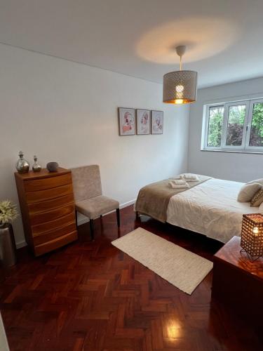 a bedroom with a bed and a dresser and a chair at Casa da Praça in São João da Madeira