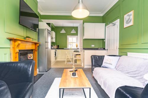 uma sala de estar com paredes verdes, um sofá e uma mesa em Monthly Discounts,10 Guests, Business em Leicester