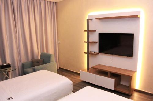 um quarto de hotel com uma cama e uma televisão de ecrã plano em Beverly Hotel Beirut em Beirute