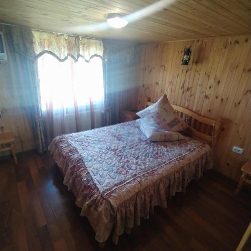 ラーゼシュチュナにあるМальваの木製の部屋にベッド1台が備わるベッドルーム1室があります。