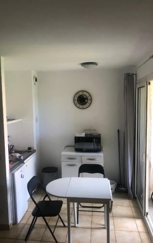 une cuisine avec une table et des chaises dans une pièce dans l'établissement Agreable studio début Cap Corse proche Bastia, à San-Martino-di-Lota